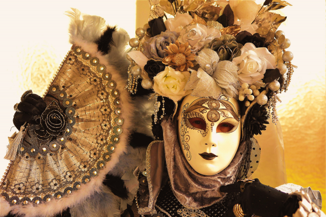 Person wearing an ornate Venetian mask with elaborate costume, symbolising hidden identity and emotional performance, exactly in the same way people are at the beginning of a relationship