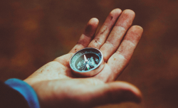 Close-up of a hand holding a compass, representing direction and movement is always needed in a relationship