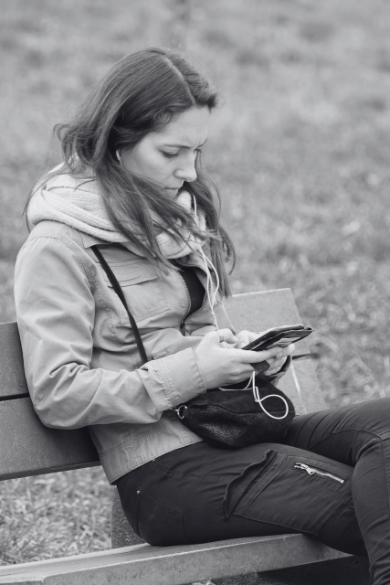 Woman sitting on a bench looking at her phone